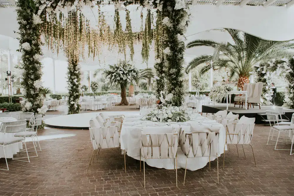 Planner arranging intricate floral details on a reception table