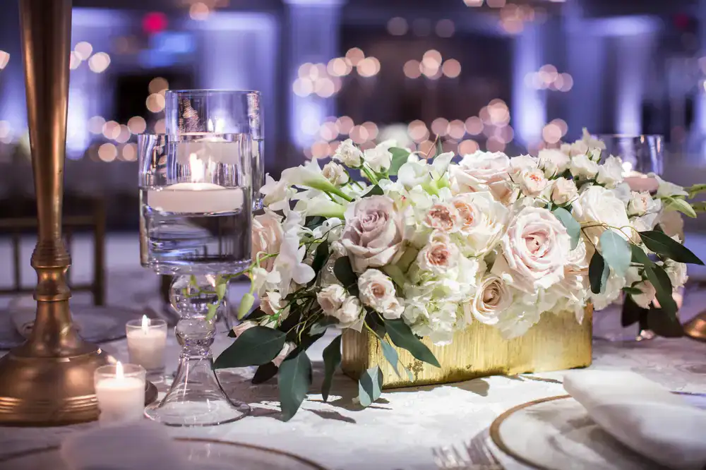 Elegant table setting featuring warm gold accents and lush floral centerpieces